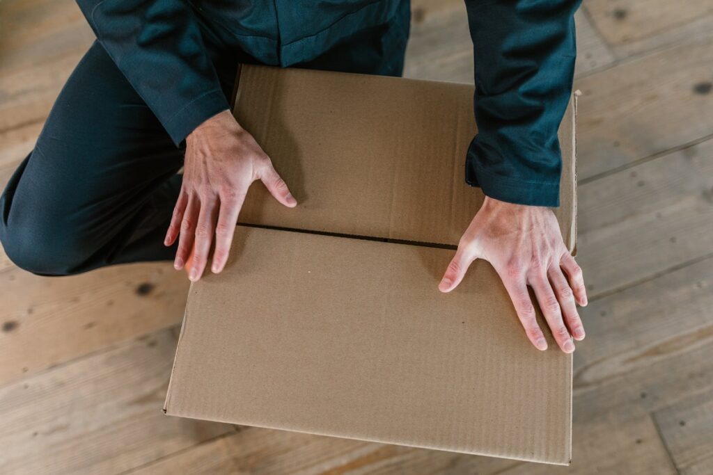 a cardboard box being closed by man
